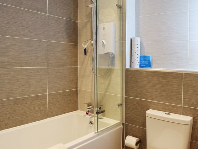 The fully tiled, modern bathroom has a shower of the bath | 7 Ladstock Hall - Ladstock Hall, Thornthwaite