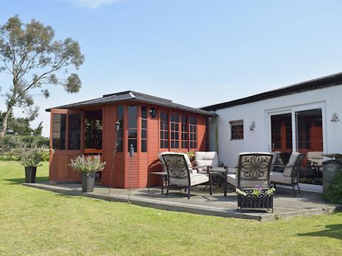 Patio with garden furniture and shared hot tub. | Leanda Lodge, Burgh Castle, near Great Yarmouth