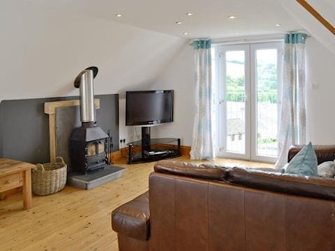 Spacious living room with wood-burner and French doors with &lsquo;juliet&rsquo; balcony | Silver Cottage, Combe Martin, near Ilfracombe