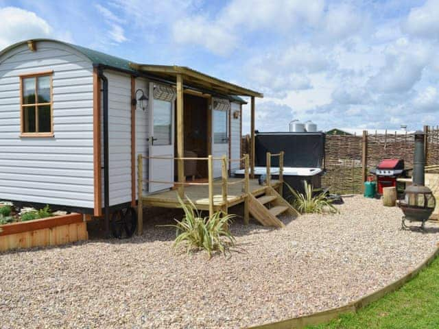 Lawned garden with patio, garden furniture, gas BBQ, fire pit and hot tub | The Swaledale - West Hale Shepherd&rsquo;s Huts, Burton Fleming, near Filey