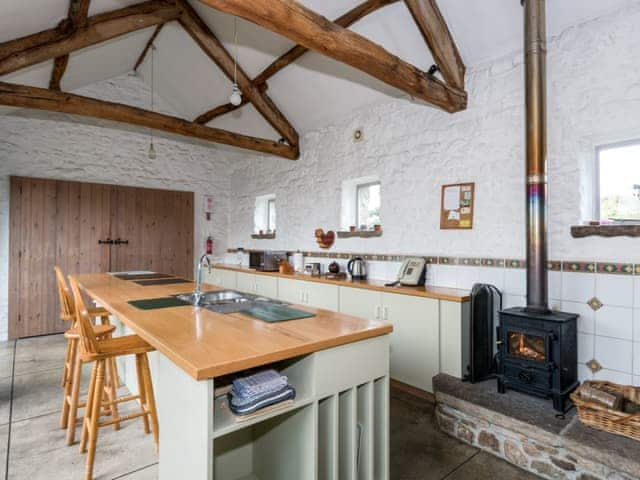 Kitchen/diner with exposed beams and a wood burning fire | Cowdber Barn, Burrow, Kirkby Lonsdale