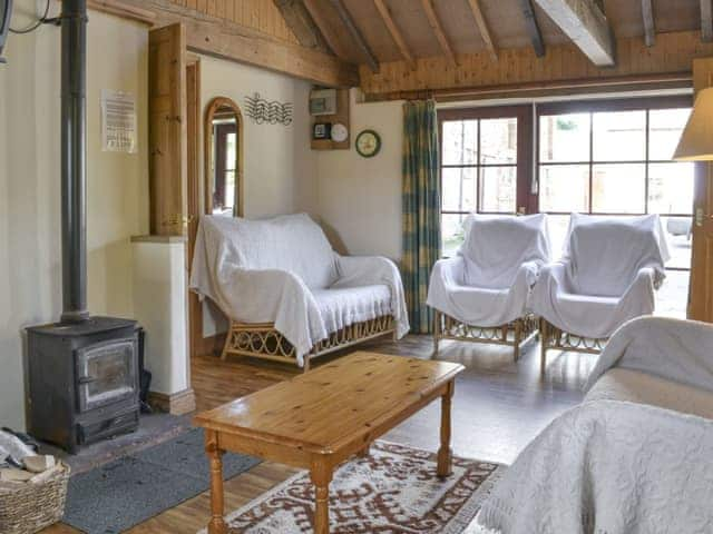 Wood burner in lounge area of open-plan room | The Byre, Newby, near Appleby-in-Westmorland