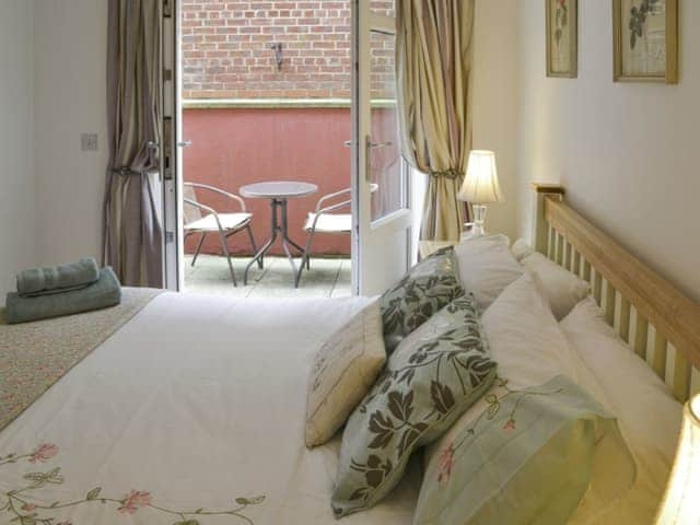 French doors in double bedroom lead to private terrace with outdoor furniture | Number 7, Whitby