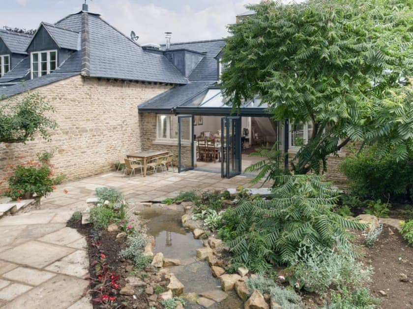 Large patio with garden area to rear of holiday home | Berry Pen Cottage - Kingham Cottages, Kingham, near Chipping Norton