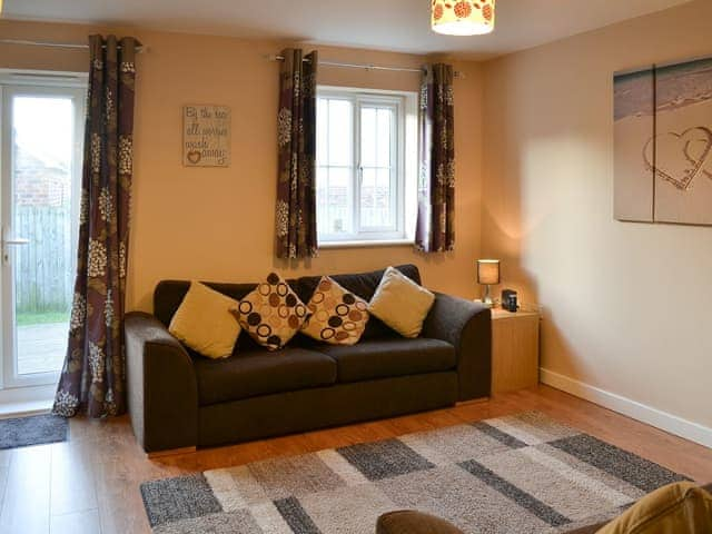 Living room with French doors leading to the garden | Puffin Place, Beadnell, near Seahouses