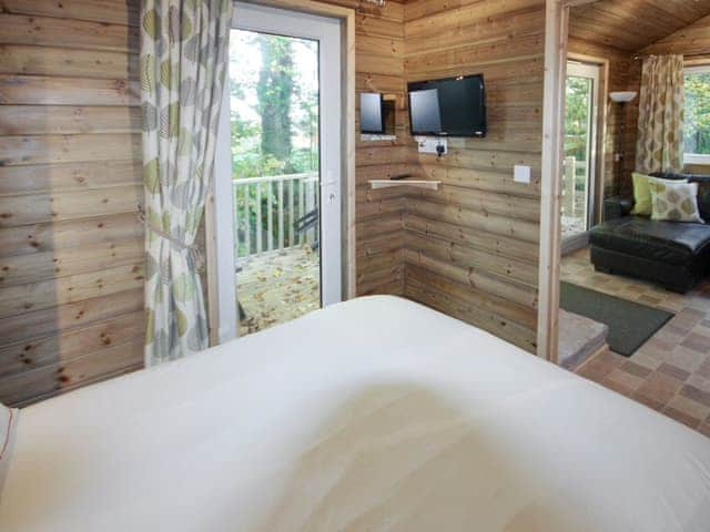 Wall-mounted TV in double bedroom | Treehouse Cabin - Wallace Lane Farm Cottages, Brocklebank, near Caldbeck and Uldale