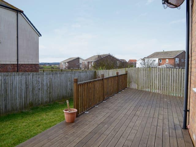  Enclosed lawned garden with decked area and garden furniture | Puffin Place, Beadnell, near Seahouses