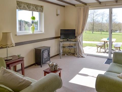 Spacious living area with patio door to garden area | Walnut - Thornbury Holiday Park, Woodacott, near Holsworthy