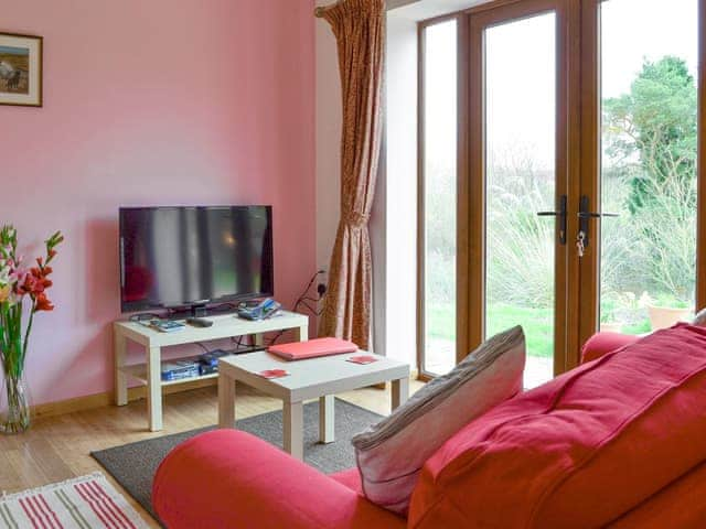 Cosy living room with double doors to patio | Spindlestone - Wide Sky Cottages, Lowick, near Berwick-on-Tweed