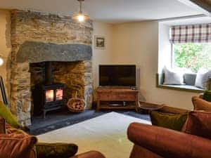 Cosy living room with wood burner and slate floor | Maybill Cottage, Cwm Penmachno, near Betws-y-Coed