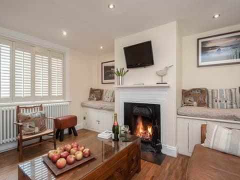 Cosy living room with open fire and wooden floor | Pebble Cottage, Aldeburgh