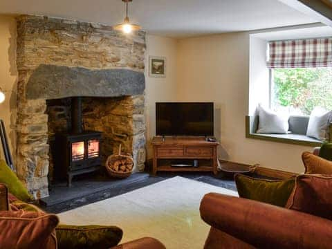 Cosy living room with wood burner & slate floor | Maybill Cottage, Cwm Penmachno, near Betws-y-Coed