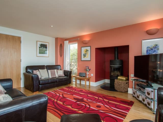 Open plan style living space with wood burning stove | The Augusta House, Somerford Keynes