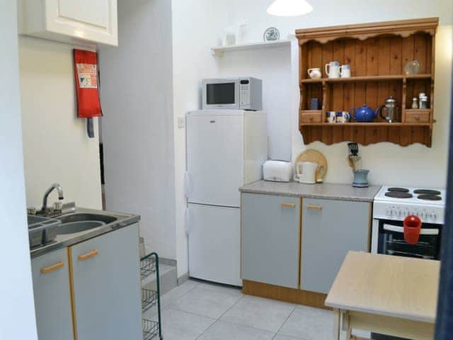 Kitchen area with electric cooker, microwave, fridge and freezer | Cloisters Cottage - Peregrine Hall Cottages, Lostwithiel