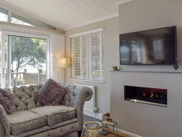 Wall-mounted fire and large TV in living area | Seacliff, Corton, near Lowestoft