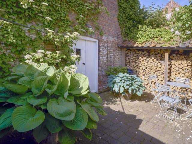 Patio and log store area with outdoor furniture | Madeleine&rsquo;s Barn, Wells-next-the-Sea