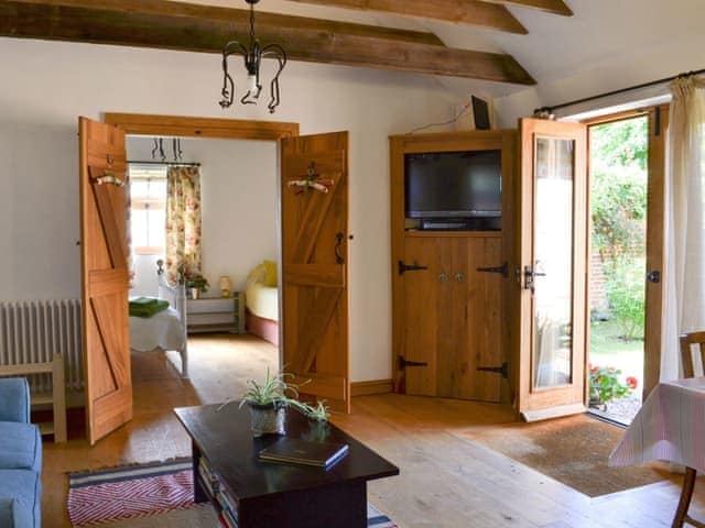 Open plan living space with beamed ceiling | Cowslip Cottage - Wildmore Cottages, New York, near Boston