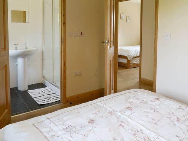 Comfortable double bedroom with en-suite shower room | Tarka&rsquo;s Holt Log Cabin - Stowford Lodge Holiday Cottages, Langtree, near Great Torrington