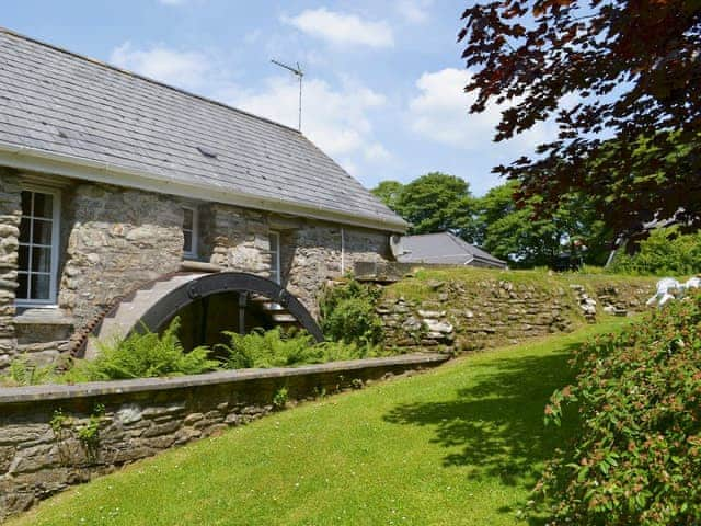 Surrounded by lawns, flowering shrubs and mature trees | TrethinDovecote, Advent