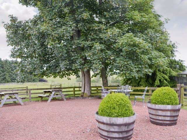 Gravelled shared patio area with outdoor furniture | Soppit Farm Cottages, Elsdon