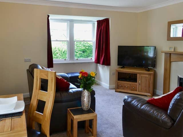 Attractive living and dining room with feature fireplace | 2 Lonsdale House - Greta Grove Apartments, Keswick