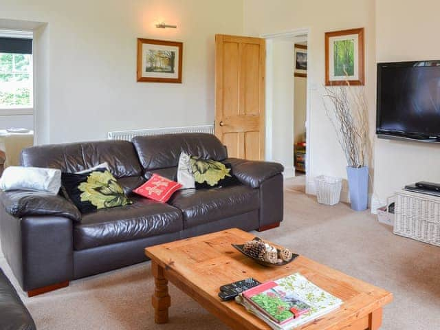 Living/dining room with contemporary leather sodas | Station Master&rsquo;s House - Torver Station Cottages, Torver, near Coniston