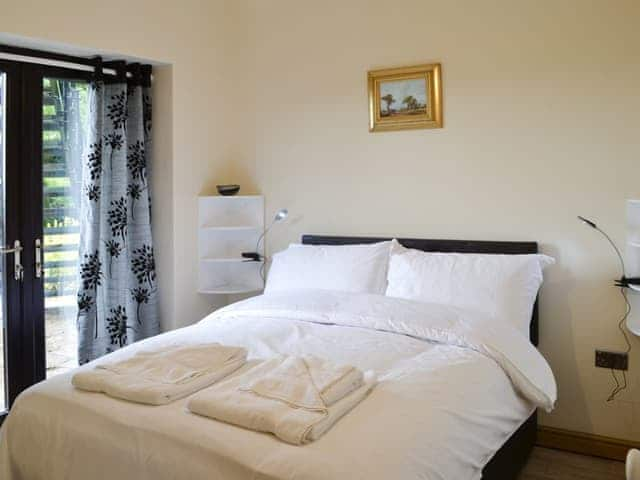 Inviting double bedroom with sliding doors to the garden | Grooms Cottage - Arkleby Holiday Homes, Arkleby, near Cockermouth