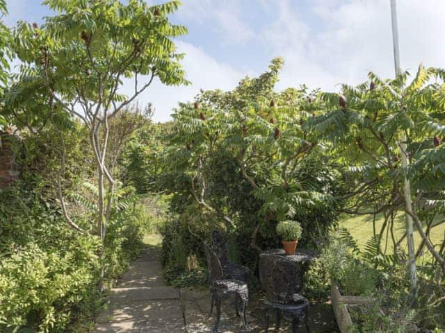 Patio area overlooking the established garden | Dell Cottage, Mundesley, near North Walsham