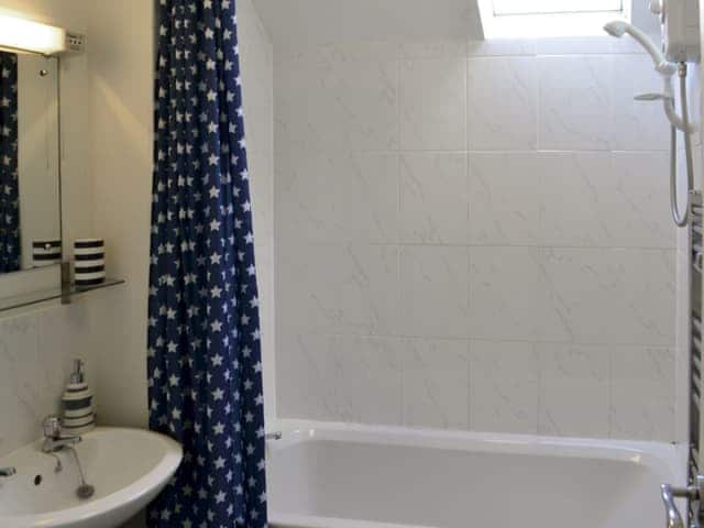 Bathroom with shower over bath and heated towel rail | Pottergate Cottage, Wroxham