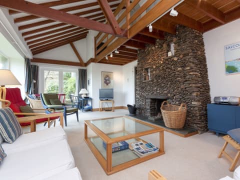 Large sitting room with feature open fireplace, picture window and doors leading out on to patio  | Spring Shaw, Salcombe