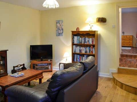 Charming wood-floored living/dining room a short step down from the bedroom | The Stables at Old Vicarage Cottage, Betws-Yn-Rhos