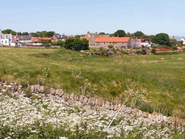 The holiday home is the long stone building with red roof | The Old Granary, Holy Island, near Berwick-upon-Tweed