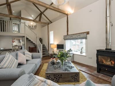 Cosy living room with wooden flooring and vaulted ceiling | Heron Barn, Lamas, near Buxton