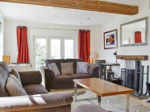 Stylish living room with wood burning stove and access to balcony | The Mill Race, Applethwaite near Keswick