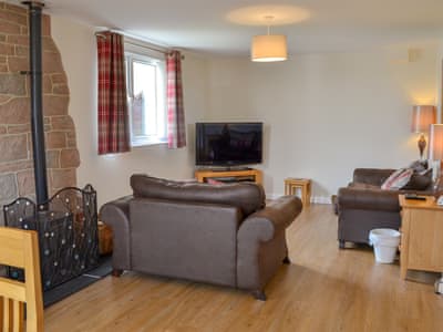 Lovely and welcoming living area with wood burner | The Old Parish Hall, Seahouses, near Alnwick