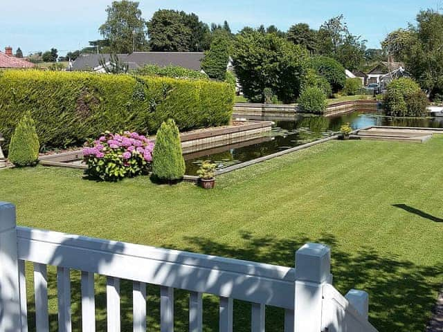 Lawned garden leading to the waters edge | The Willows, Hoveton, near Wroxham