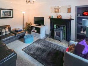 Stylishly furnished living room with wood burner | 2 Northbank Cottages, Whiting Bay, Isle of Arran