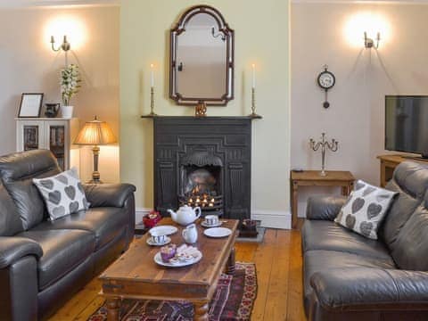 Delightful living/ dining room with a cosy fire | Rosehip Cottage, Alnwick