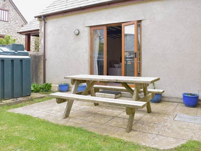 Paved patio area with outdoor furniture | Sawmill Cottage - The Old Timberyard, Puncknowle, near Dorchester