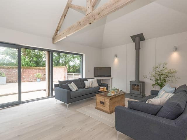 Welcoming living area with wood burner | The Cowshed, Reepham