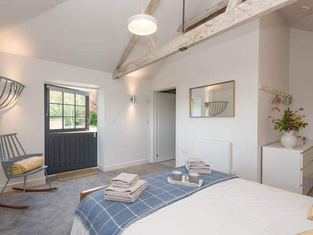 Light and airy en-suite double bedroom with door to enclosed patio | The Cowshed, Reepham