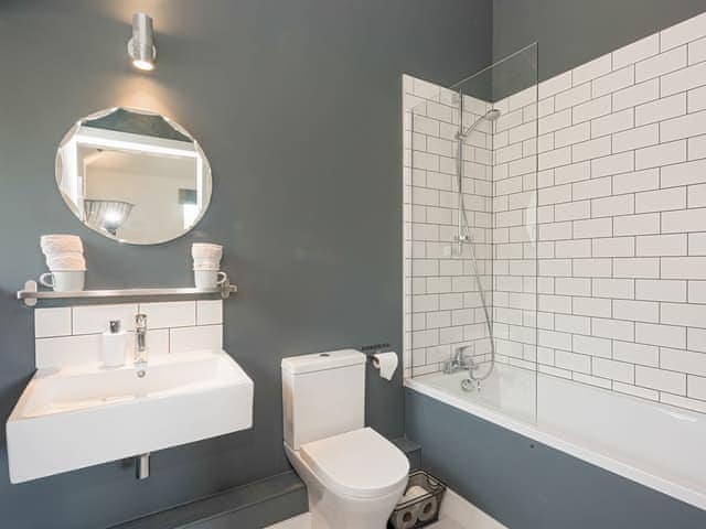 En-suite bathroom with shower over bath | The Cowshed, Reepham