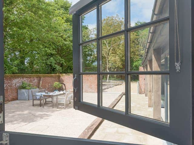 View from second double bedroom to enclosed patio | The Cowshed, Reepham