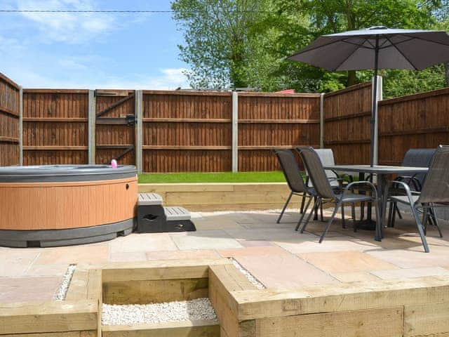 Split-level enclosed patio and garden with outdoor furniture and hot tub | The Old Stables - Swafield Barns, Swafield, near North Walsham