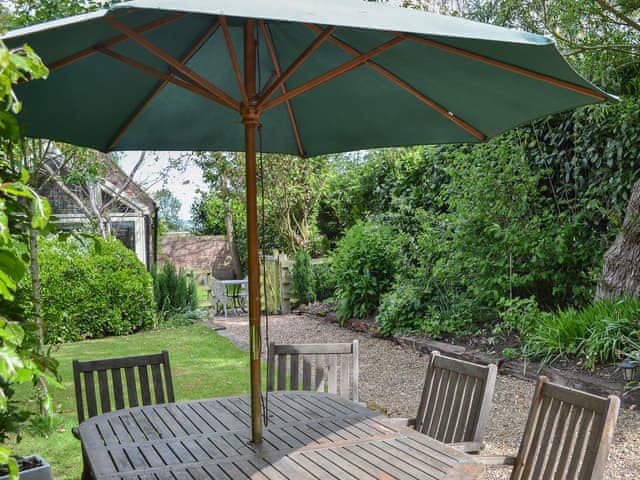 Shady table and chairs in the garden for alfresco entertaining | Mill Cottage, Bielby, near York