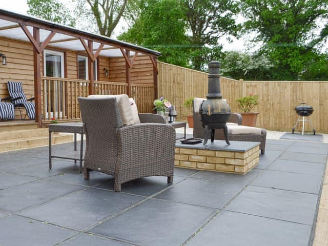 Paved patio area with outdoor furniture | Cedar Lodge, Cowbeech, near Hailsham