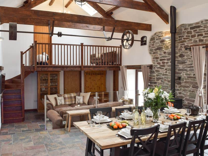 Open plan living space with beams and slate floor | Wheelwright Barn - Bronyn Farm, Ferryside, near Carmarthen