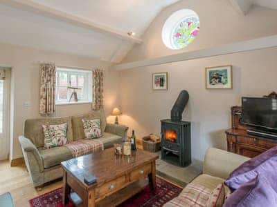 Warm and welcoming living room with cosy wood burner | Walkmill Lodge, Norbury, near Bishop’s Castle