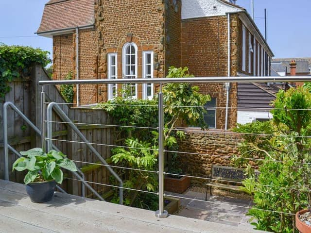 Wooden balcomy overlooking the courtyard style garden | The Mistress&rsquo; House, Hunstanton