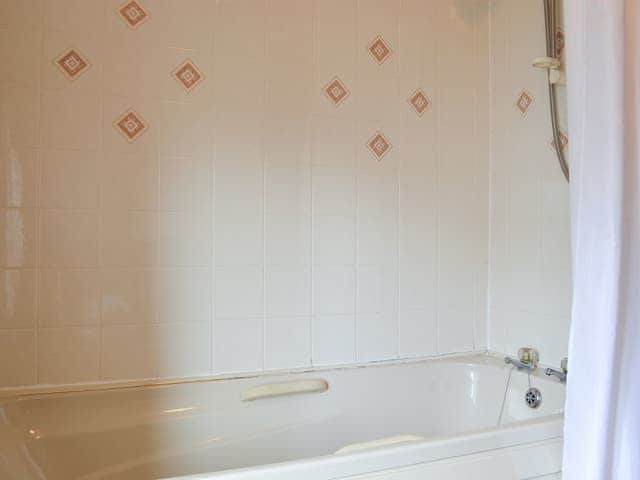 Tiled bathroom with shower over bath | The Cider Mill Cottage, Orleton, near Ludlow